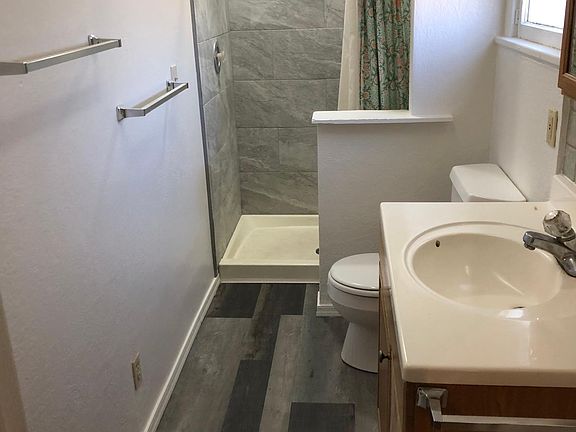 Rear bathroom with new paint, flooring, and ceramic tile in shower. directly from primary bedroom. Not shown is the new ceiling alcove and lighting.