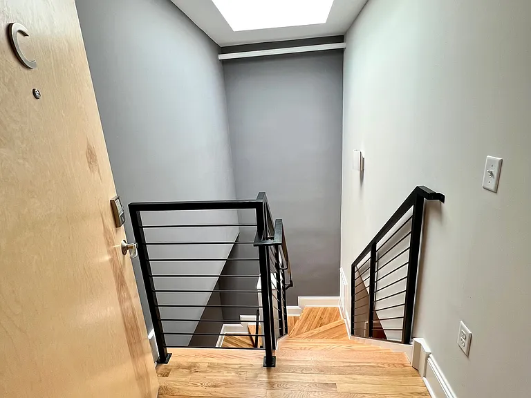 Front door view into the apartment showing the skylight which filters light all the way to the bedroom level.