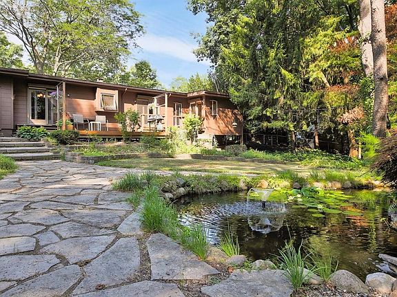 The rear of the home shows the Koi Pond in the foreground.