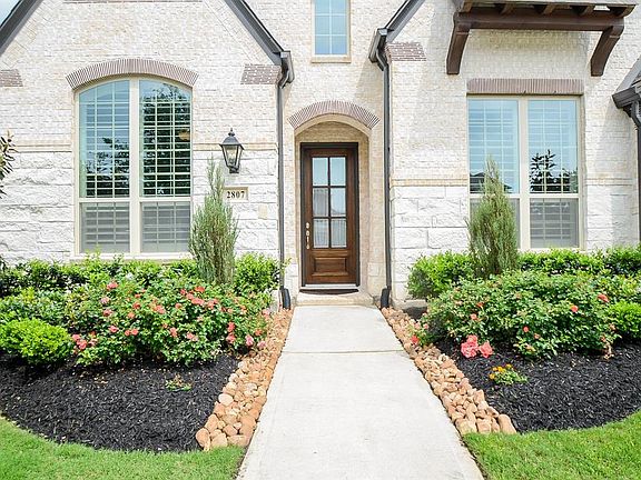 This is your next "Happy Place." White stone and brick with wood accents in all the right places make this rustic modern exterior feel like "home." The landscaping is lush and plentiful to greet all of your guests and provide beautiful curb appeal.