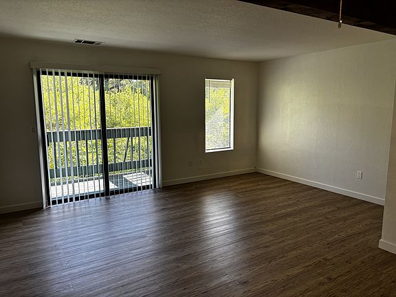 Spacious living and dining area with balcony and laminate flooring