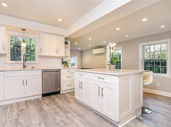 Brand new open concept dream Kitchen with quartz countertops, subway tile backsplash, stainless steel appliances, and ample cust