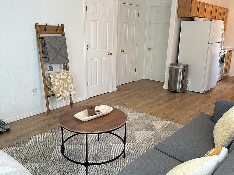 Living room with 2 closets (on left) and half bath with laundry (behind refrigerator/kitchen wall).