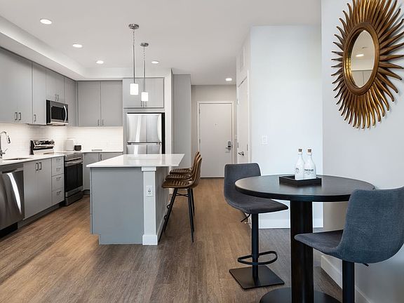 Kitchen, living, and dining areas with hard surface flooring throughout
