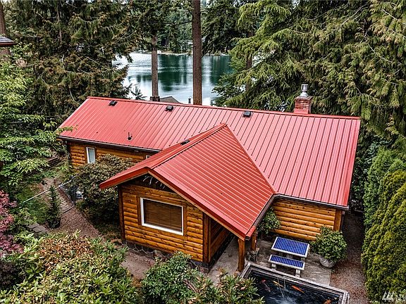 View of the main house with a NEW 40 year metal roof installed in 2020. Log style Siding was added with love to give it a cozy cabin feel. Amazing!