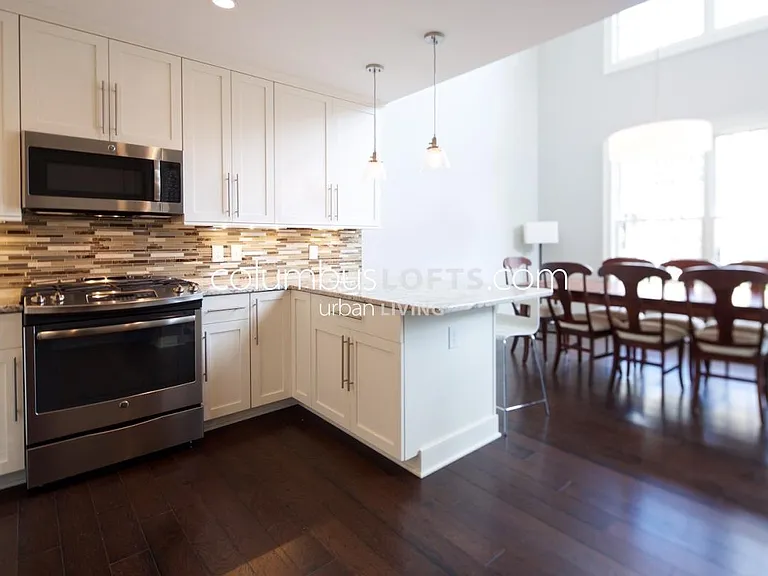 kitchen including peninsula breakfast bar, with dining room in background