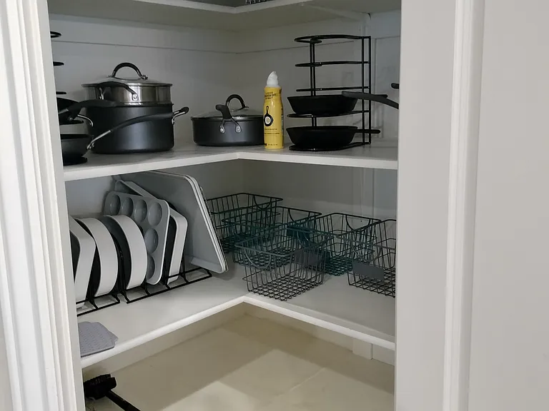 The fully furnished kitchen boasts a double oven, gas range, toaster, coffee station, spices, pots, pans, utensils, and sharp knives. It includes ample empty cupboard space for storage, providing everything you need for a seamless cooking experience.