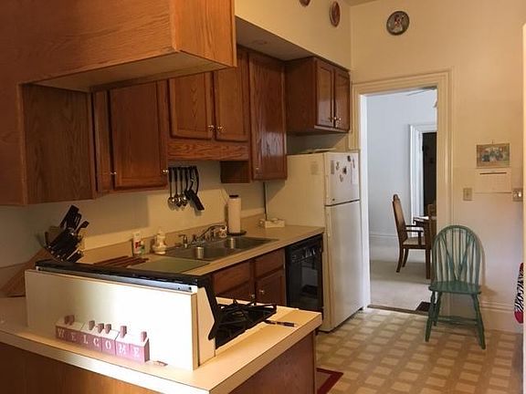 View of Kitchen from 10th Street Side Porch Door, view of entrance to Dining Room; closet housing washer & dryer hookup are on opposite side of kitchen