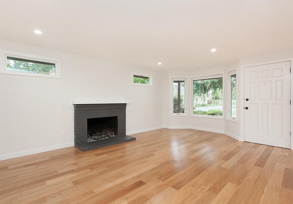 Sunlit living room hosts wood burning fireplace