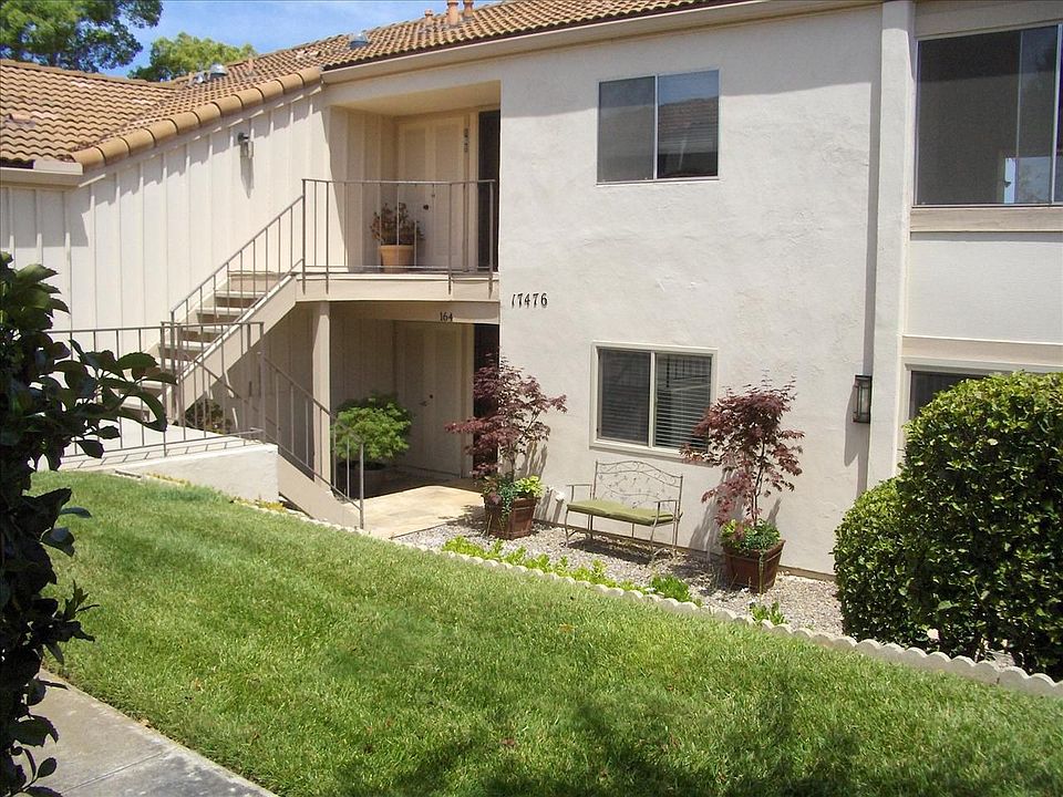 This is a lower unit with lush plants decorating the front yard.