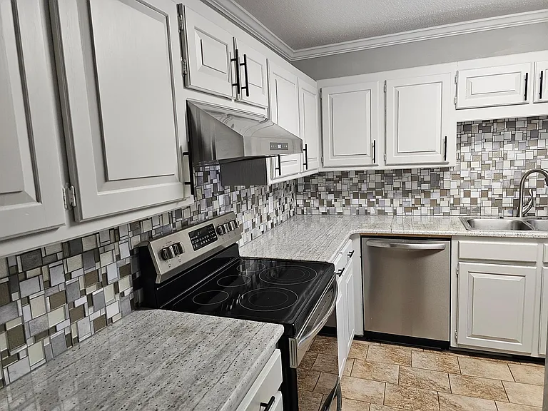 Kitchen has oven, stove top, dishwasher, & plenty of cupboards.
