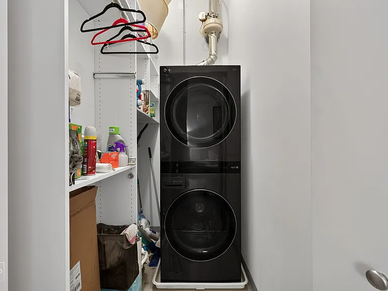 In unit washer and dryer alongside a custom closet with tons of storage and a place to hang clothes.