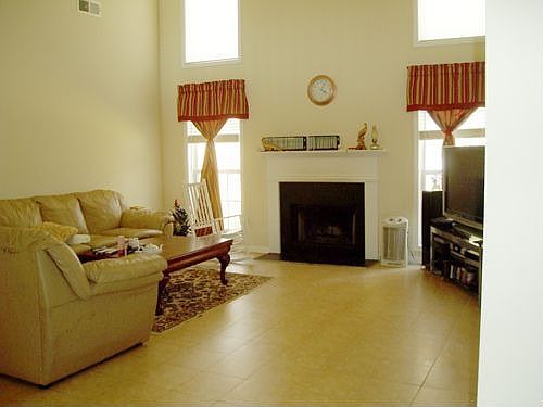 Big windows in familyroom, high ceiling, tile floor.