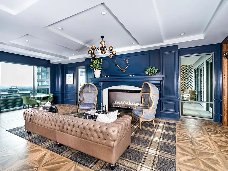 Gather fireside at Modera Old Ivy, where tailored interiors, skyline light, and inviting lounge seating create a refined setting in Atlanta.