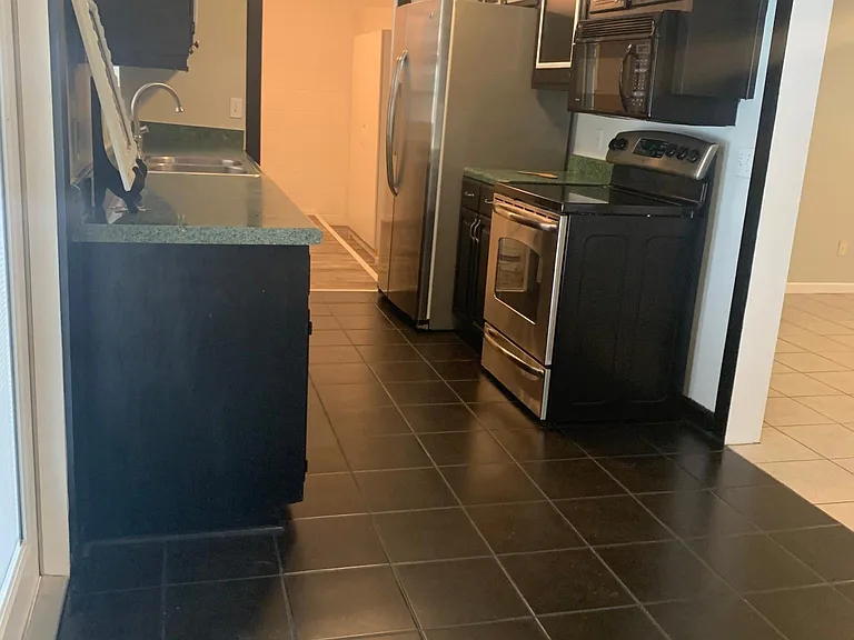 kitchen view - furnished with working appliances- dishwasher, oven glass top, large side by side refrigerator with ice maker, built in microwave, fire extinguisher, smoke detectors