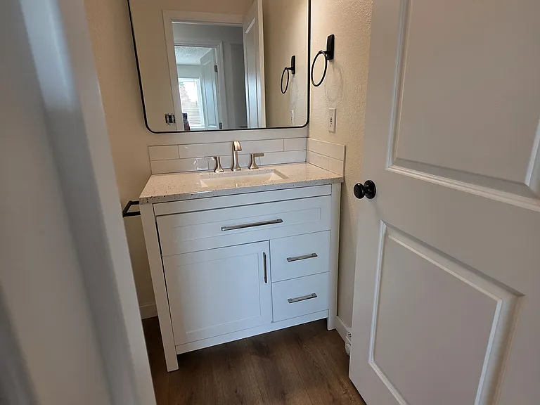 Cute updated bathroom with new vanity, mirror and light fixture