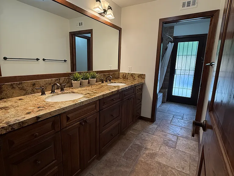 Hall bathroom with dual sinks! Tub/shower can be closed off from the sink/vanity area for additional privacy and multi-person use for busy mornings and evening routines! This bathroom has direct access to the backyard/ pool area!