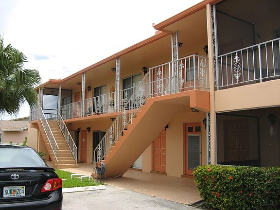 Apt 4 is to the right with patio surrounded by hedges. Laundry room is all the way to the left under the stairway next to the mailboxes.