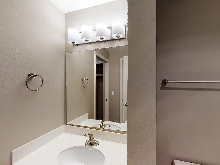 Apartment bathroom with wood-style flooring.