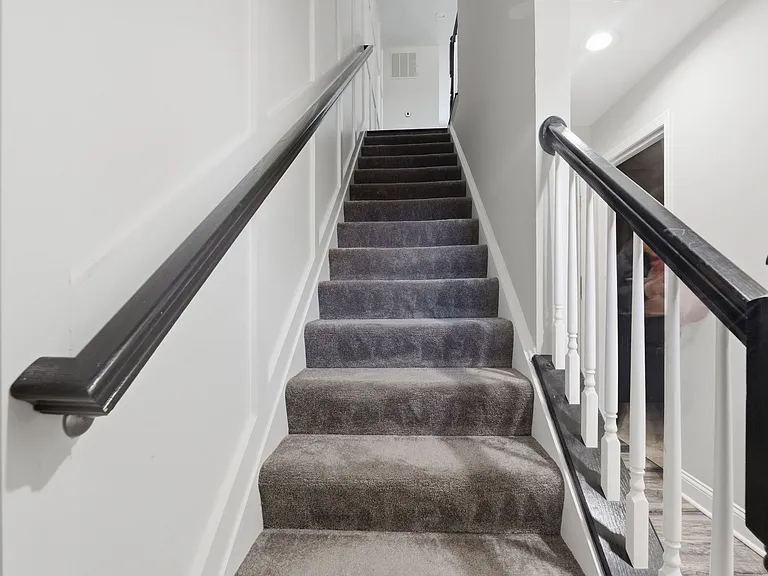 1st-floor main entrance with staircase leading to the 2nd-floor living and kitchen area.