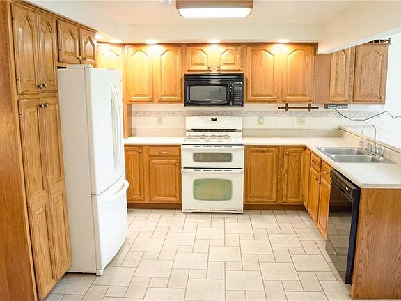 Kitchen with solid cabinets, recessed lighting, and ceramic tile