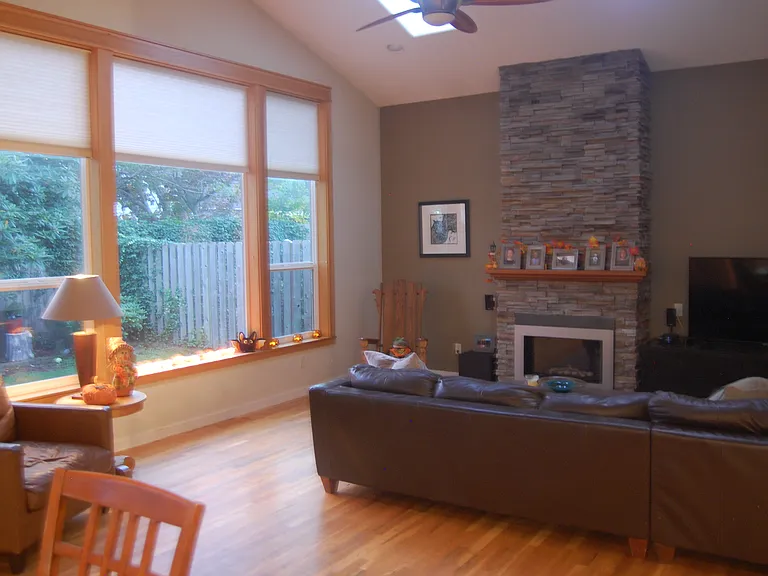 Living Room Oak Hardwood Floors, Large Bank of Windows and Stone Fireplace.