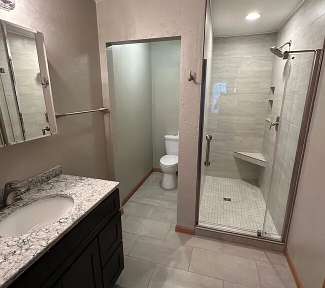 Renovated Master Bathroom with tile shower/glass door and granite countertop