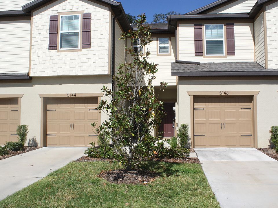 Front of condo with single car garage and driveway. More parking available opposite.