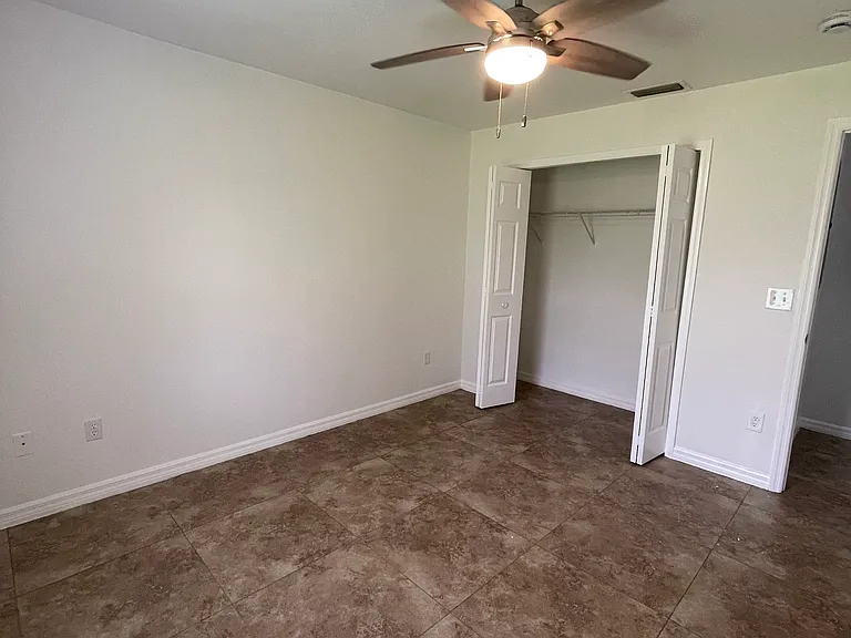 Bedroom has a new ceiling fan and freshly painted walls.