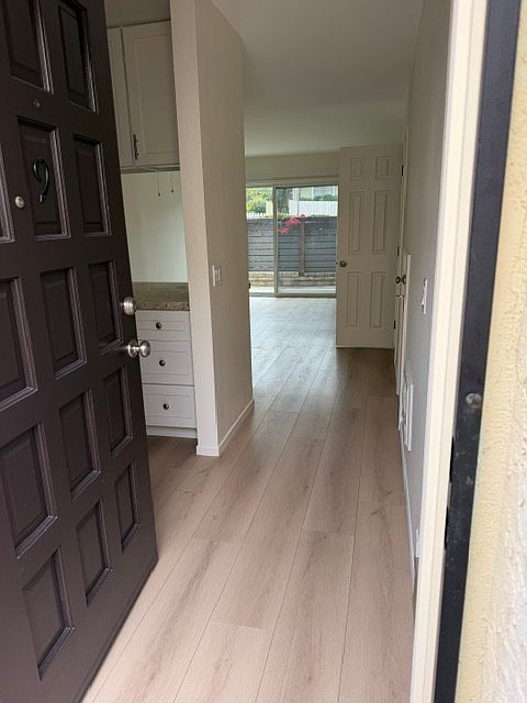 Front entrance with kitchen to the left with bar seating, living room and patio beyond. Powder room, under stairs storage and stairs to the bedrooms to the right (not visable in this picture).