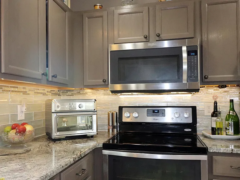 Granite countertop with tile backsplash and stainless steel cabinet