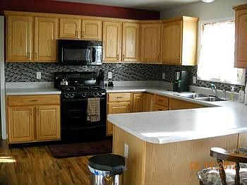 Love to cook? Here is a spacious kitchen with many cupboards and counterspace and new back splash tile, and new laminate wood flooring.