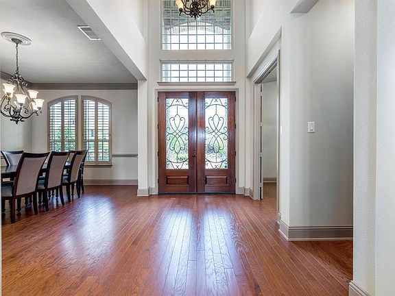 Grand entry has stunning double doors, crown molding and wood floors.