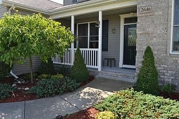 The main entance features a landscaped walkway leading to a covered front porch.