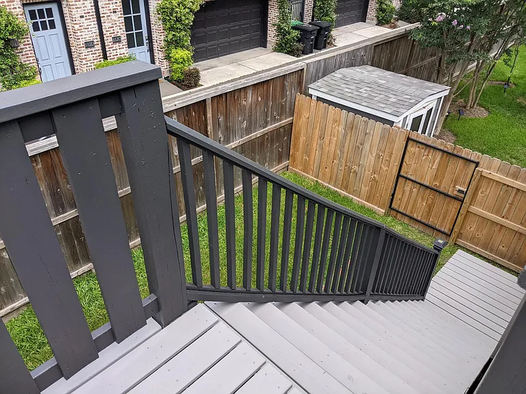 View down the stairway from apartment deck to fenced/semi-private yard.