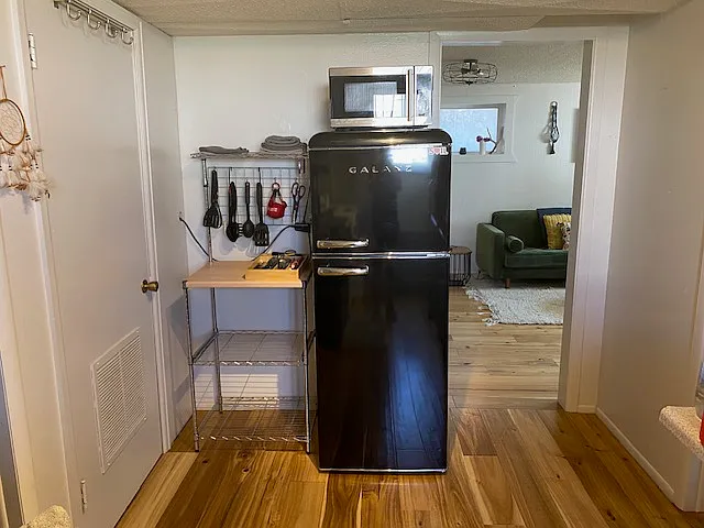 Kitchen microwave, refrigerator, storage, and access to utility closet