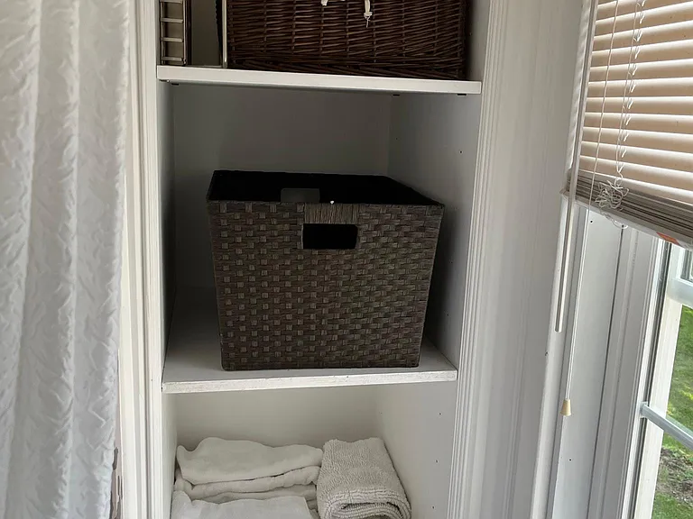 Linen closet area white bathroom.