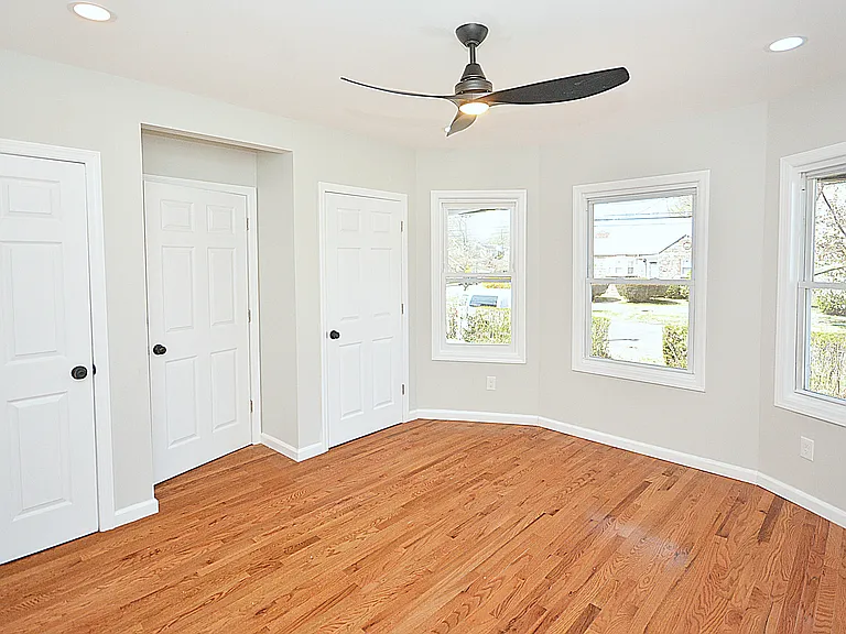 Bedroom with 2 closets providing ample storage, can lights, and ceiling fan with a light.