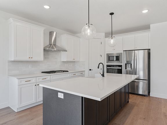 The kitchen features white wood cabinets, quartz countertops and energy-efficient appliances.