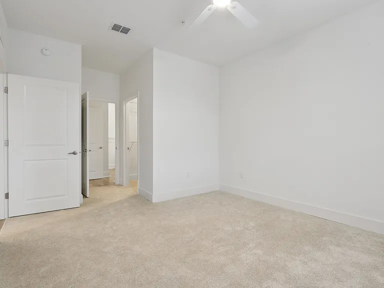 Bright and inviting bedroom with plush carpeting and open closet access, perfect for personal retreat.