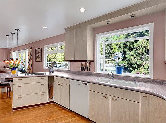 Updated kitchen with Corian counters over looks lush rear yard.