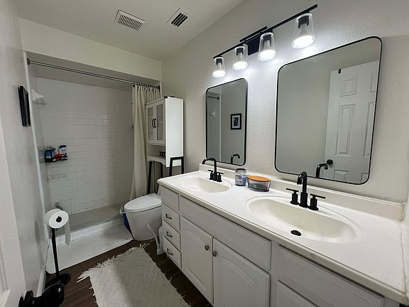 Master bathroom feauting two sinks and extra storage over the toilet