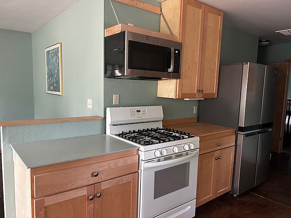 Kitchen is open living room and has refrigerator, stove/oven, microwave, dishwasher. and dining area.