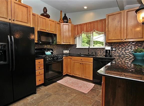 Custom cabinets, granite counter tops, tile back splash and flooring accent the kitchen.
