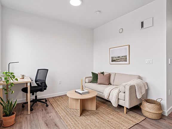 Room to live and work from home, with wide-plank flooring and a bright corner window.