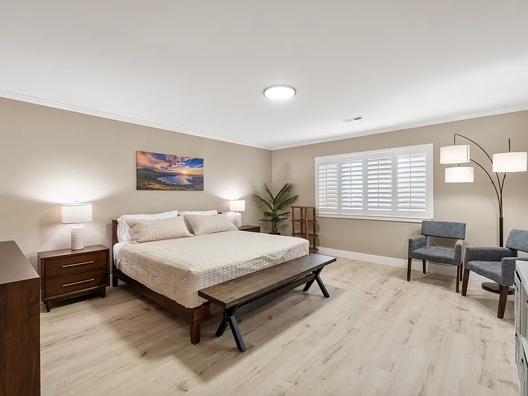 Primary Bedroom with King size bed, seating area, and 55" wall mounted Smart TV