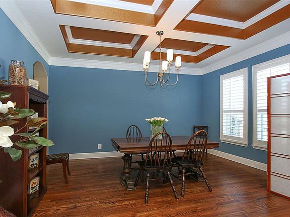 To the right of the entry is formal dining room. The coffered ceiling is a wow-factor! Oak flooring and plantation shutters also dress up this spacious entertainment space!