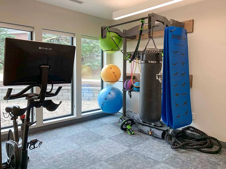 Our yoga and spin area includes tons of equipment, including a spin bike, punching bag, and fitness mirror.