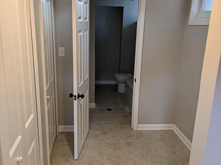 Basement Hall to Bathroom with 2 clothes closets on the left