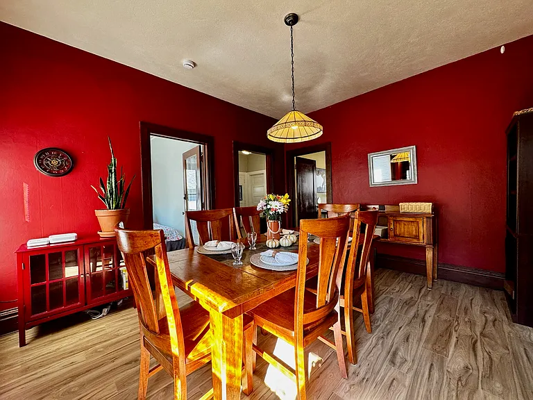 Dining room. Table seats six and has a matching hutch. There is also a large bookshelf in this room and a smaller red cabinet for storage. Wifi equiptment here, fiber internet.